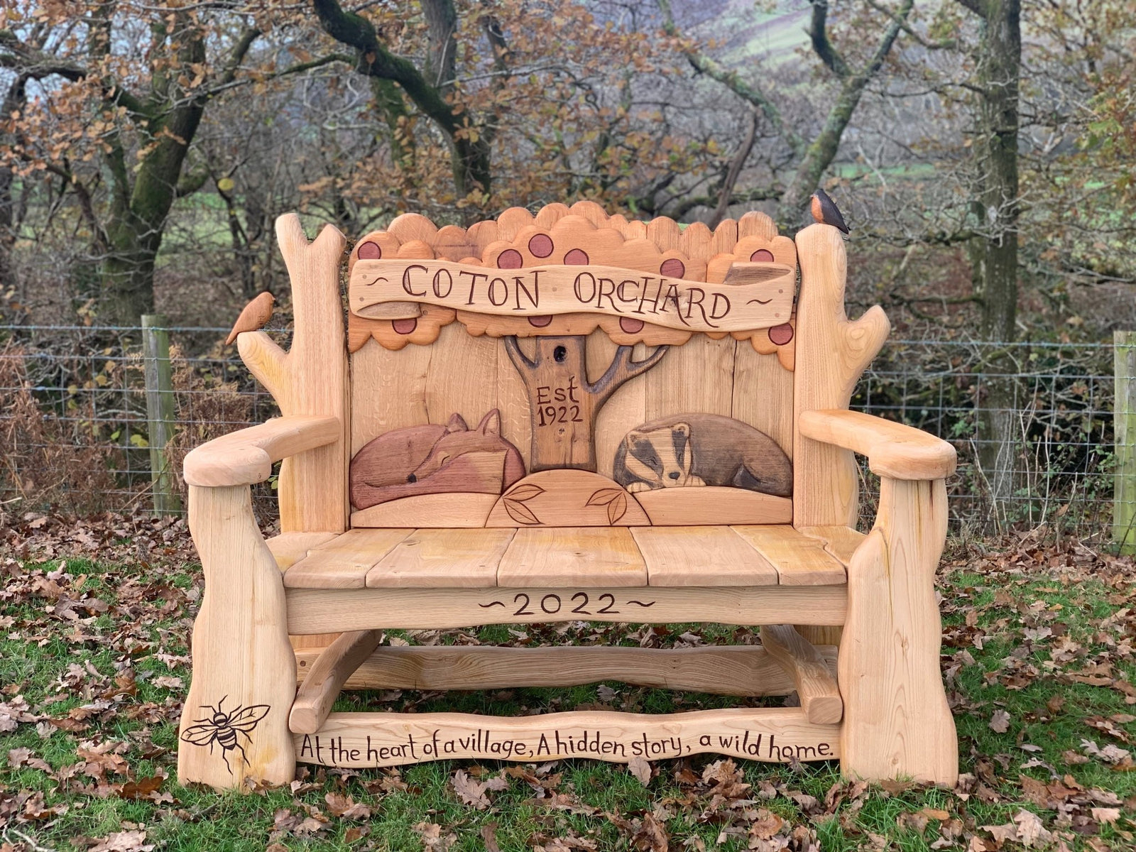 Hand-carved oak Coton Orchard Bench with wildlife motifs — bespoke 2-seater outdoor bench, handmade in Wales