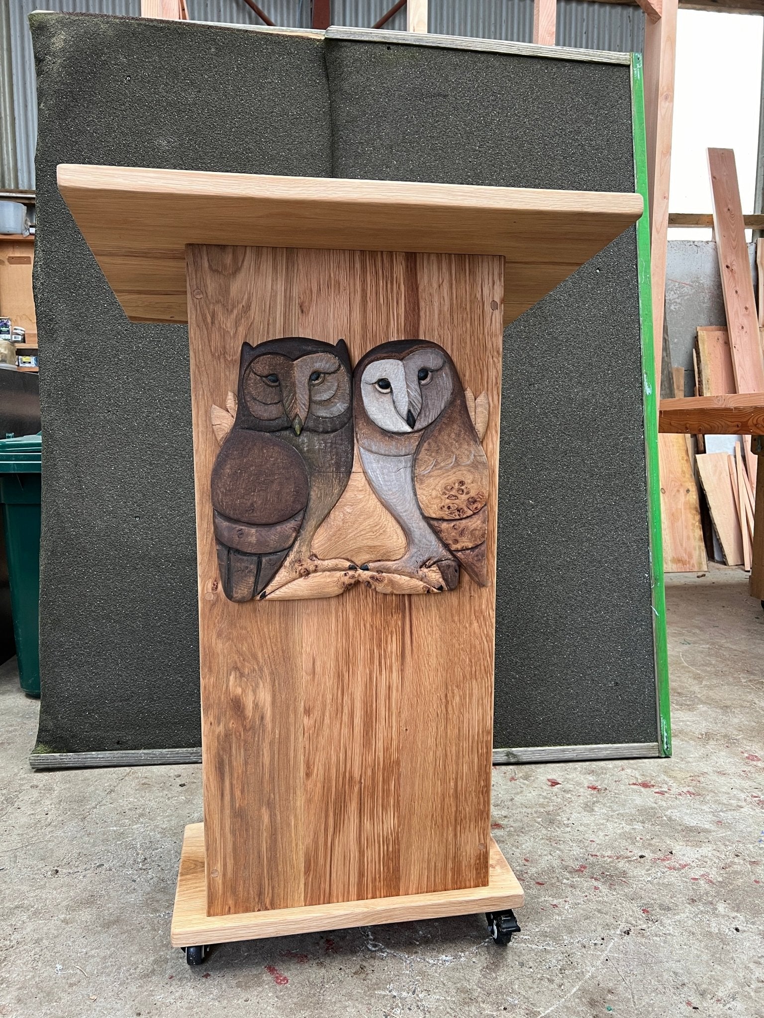 Close-up of handcrafted owl-engraved lectern on wheels, designed for school storytelling and presentations