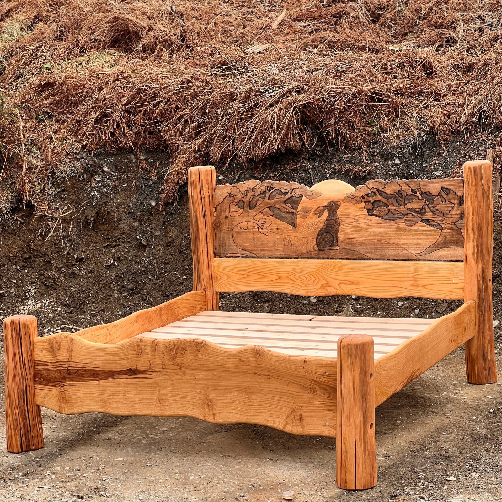 Handmade wooden bed with hare carvings against natural background — bespoke solid oak, Wales