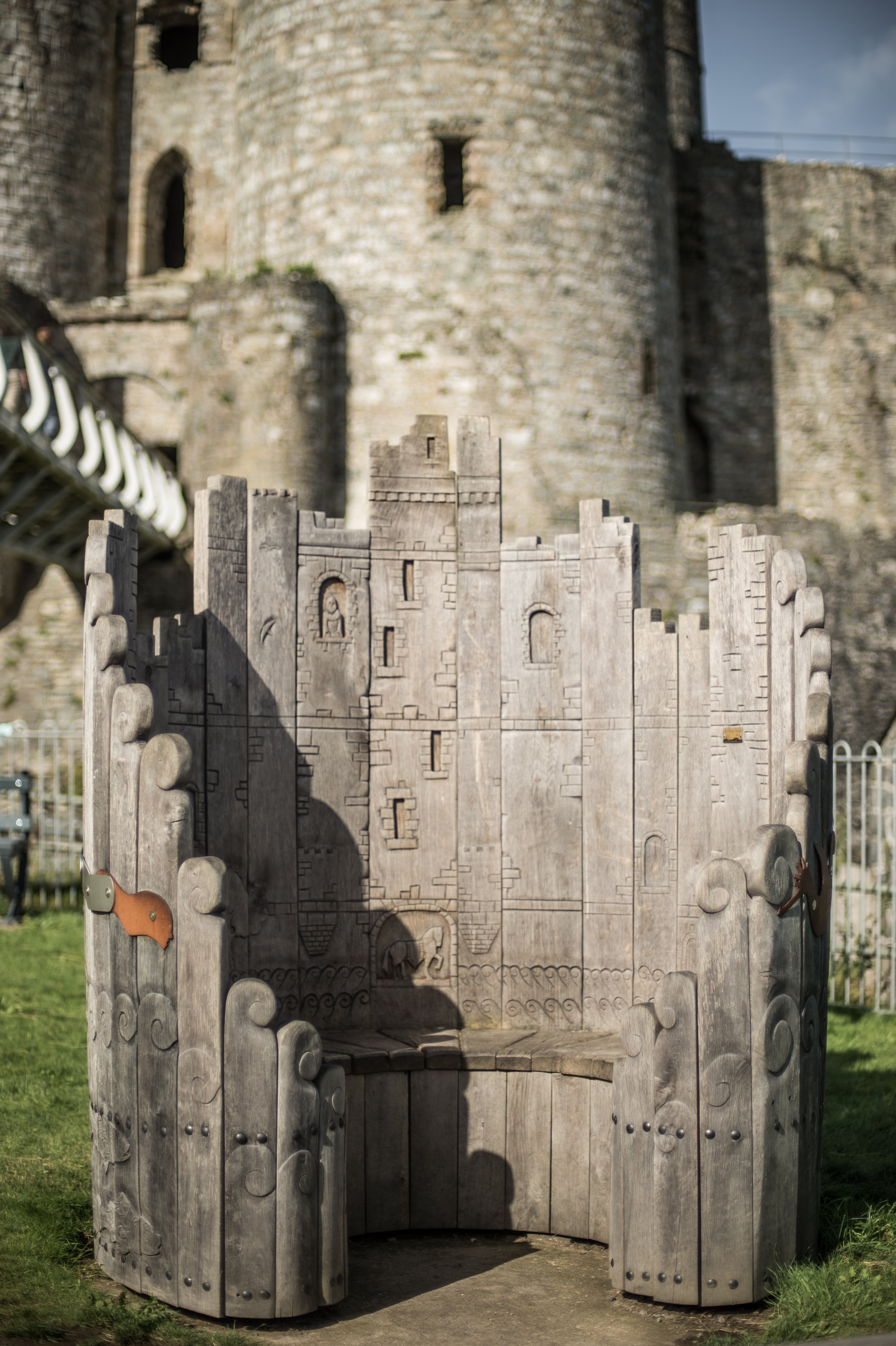 Close-up of the Harlech Castle Circular Wooden Bench showcasing intricate castle-inspired carvings and design, handcrafted from solid oak.