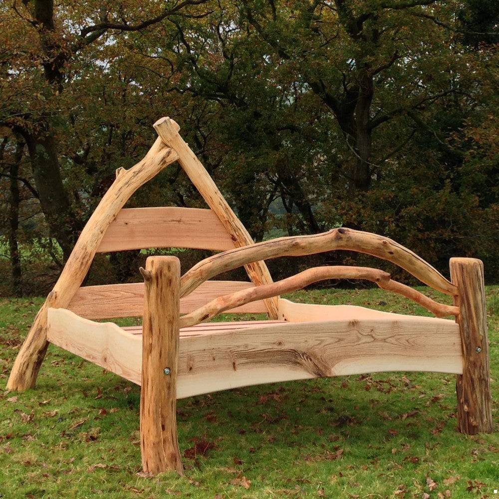 Hobbit-inspired Wooden Cruck Frame Bed with a rustic A-frame design, handcrafted from driftwood, ash, and pine, blending Medieval charm and nature's beauty.

