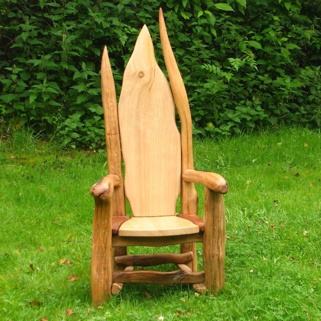 Children sitting in handmade carved hobbit storytelling chair — bespoke oak, Wales