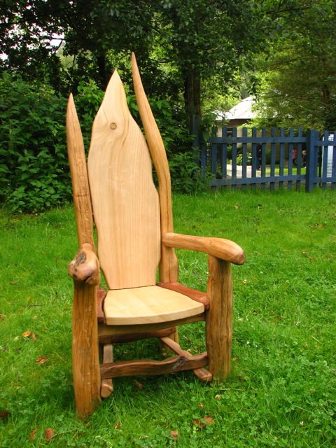 Children in carved hobbit oak garden chair — handmade storytelling furniture, Wales