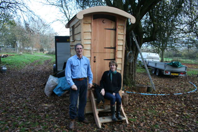 Two people posing with compost toilet