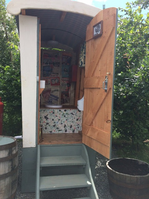 Open door of compost toilet showing interior