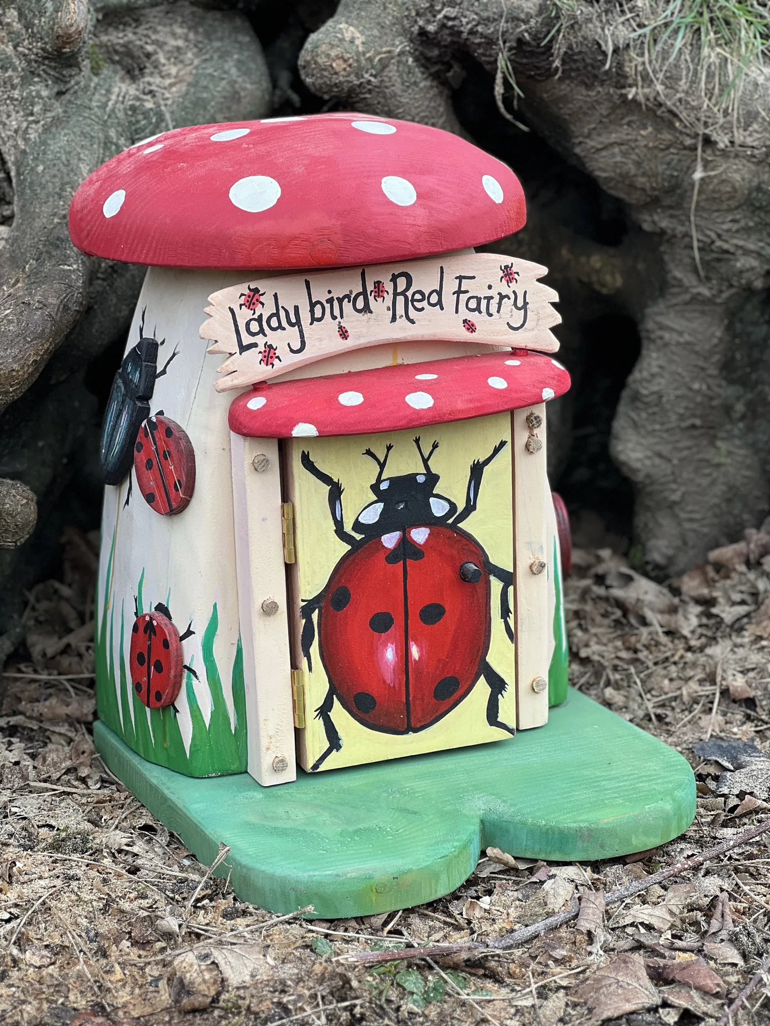 Side view of ladybird fairy house showing red spotted paintwork and handcrafted solid timber construction