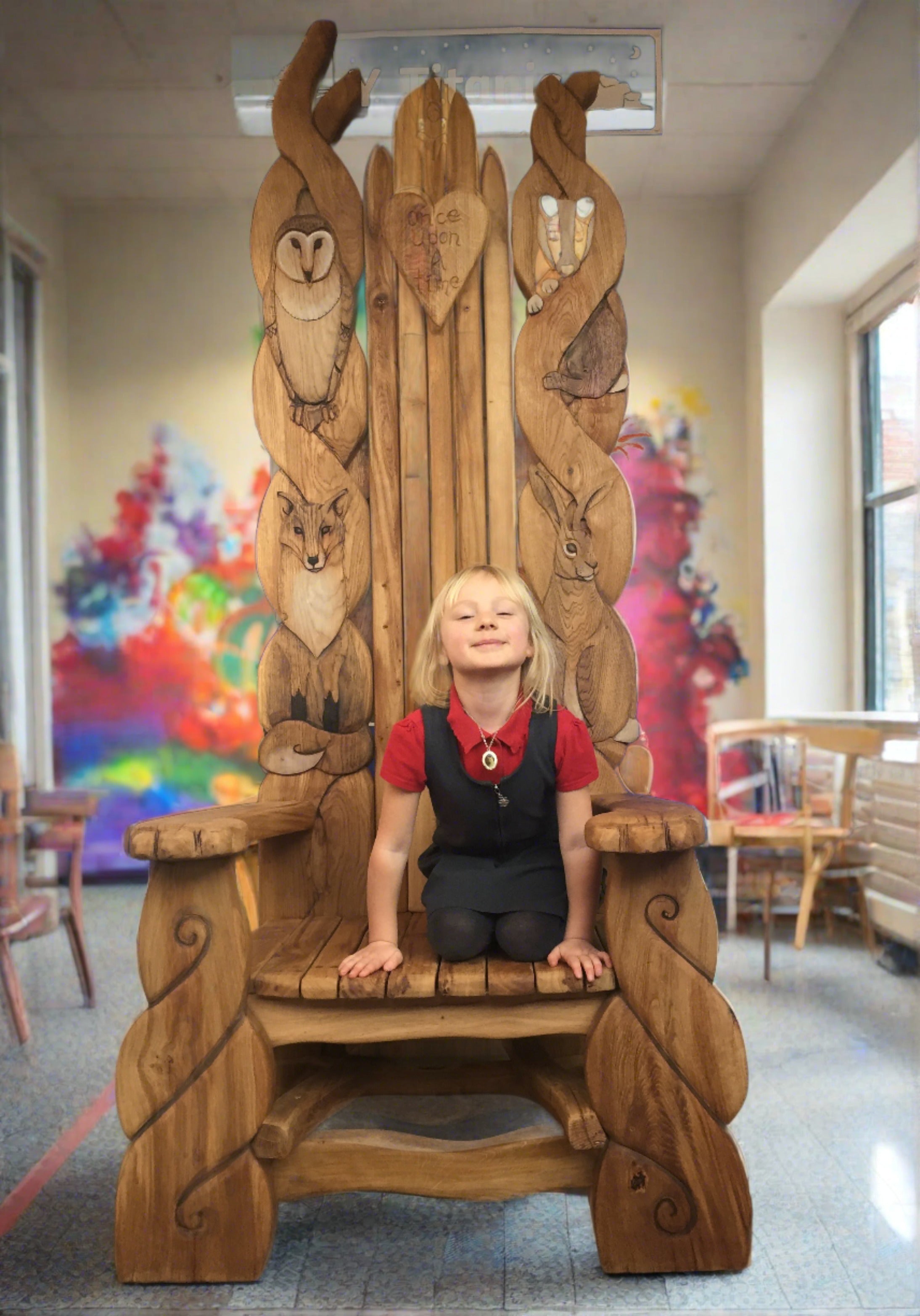 Grande chaise en bois avec des sculptures d'animaux dans une salle de classe.