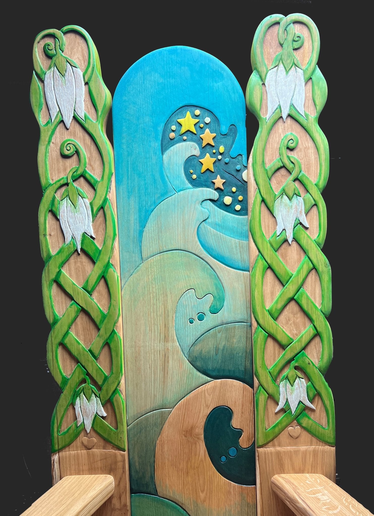 Hand-carved oak storytelling chair with painted waves, snowdrops, and stars on tall backrest