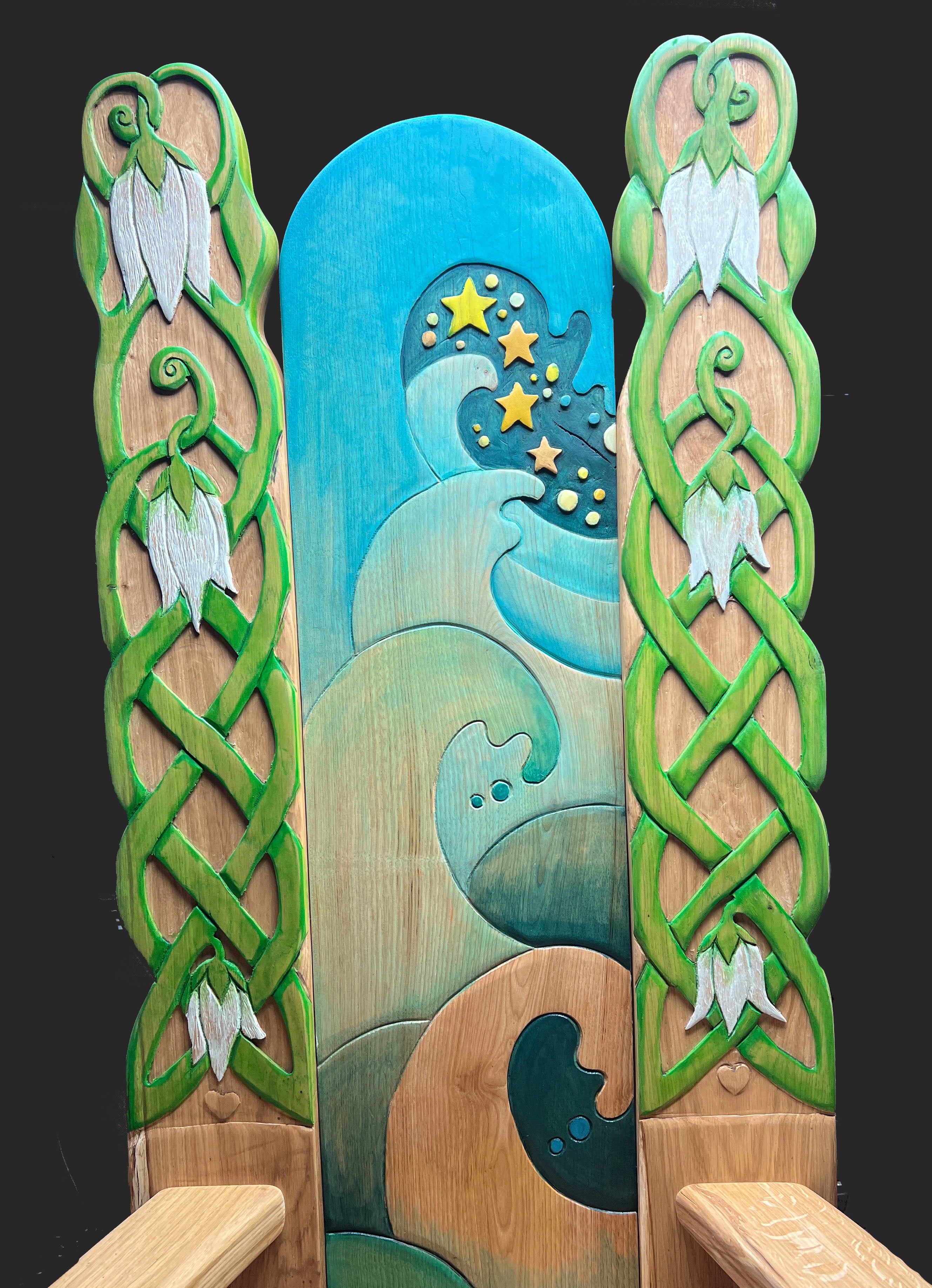 Hand-carved oak storytelling chair with painted waves, snowdrops, and stars on tall backrest