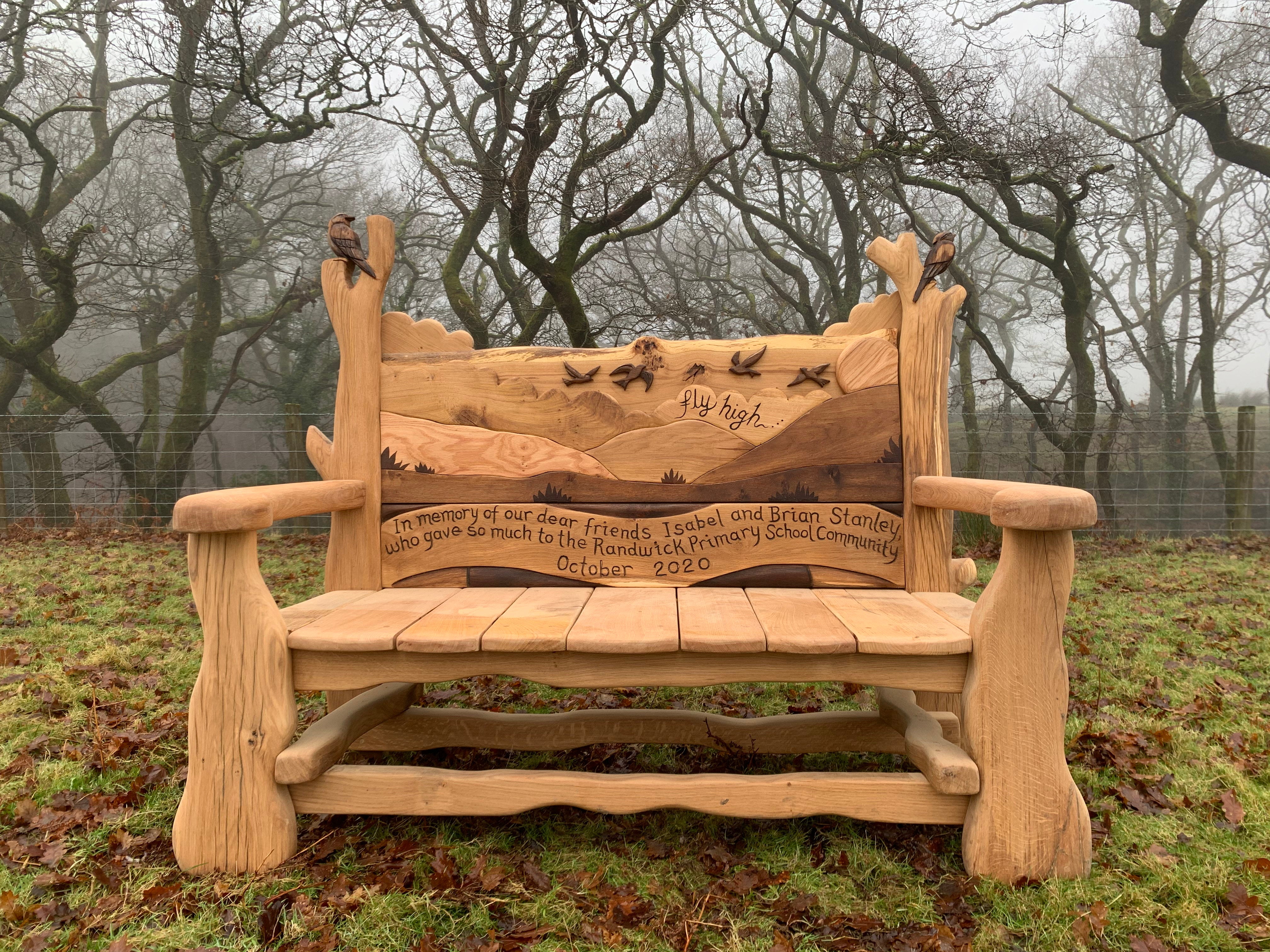 memorial garden bench with a carved backrest with a inscription   