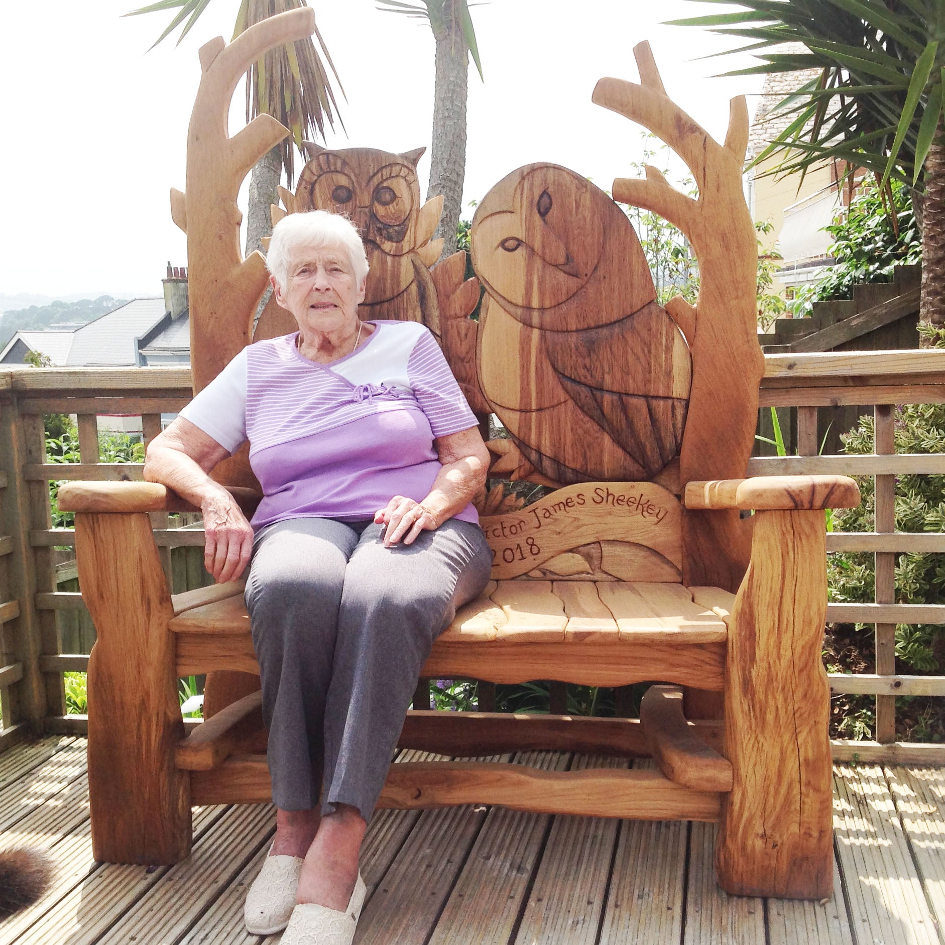 memorial-owl bench in garden on a deck