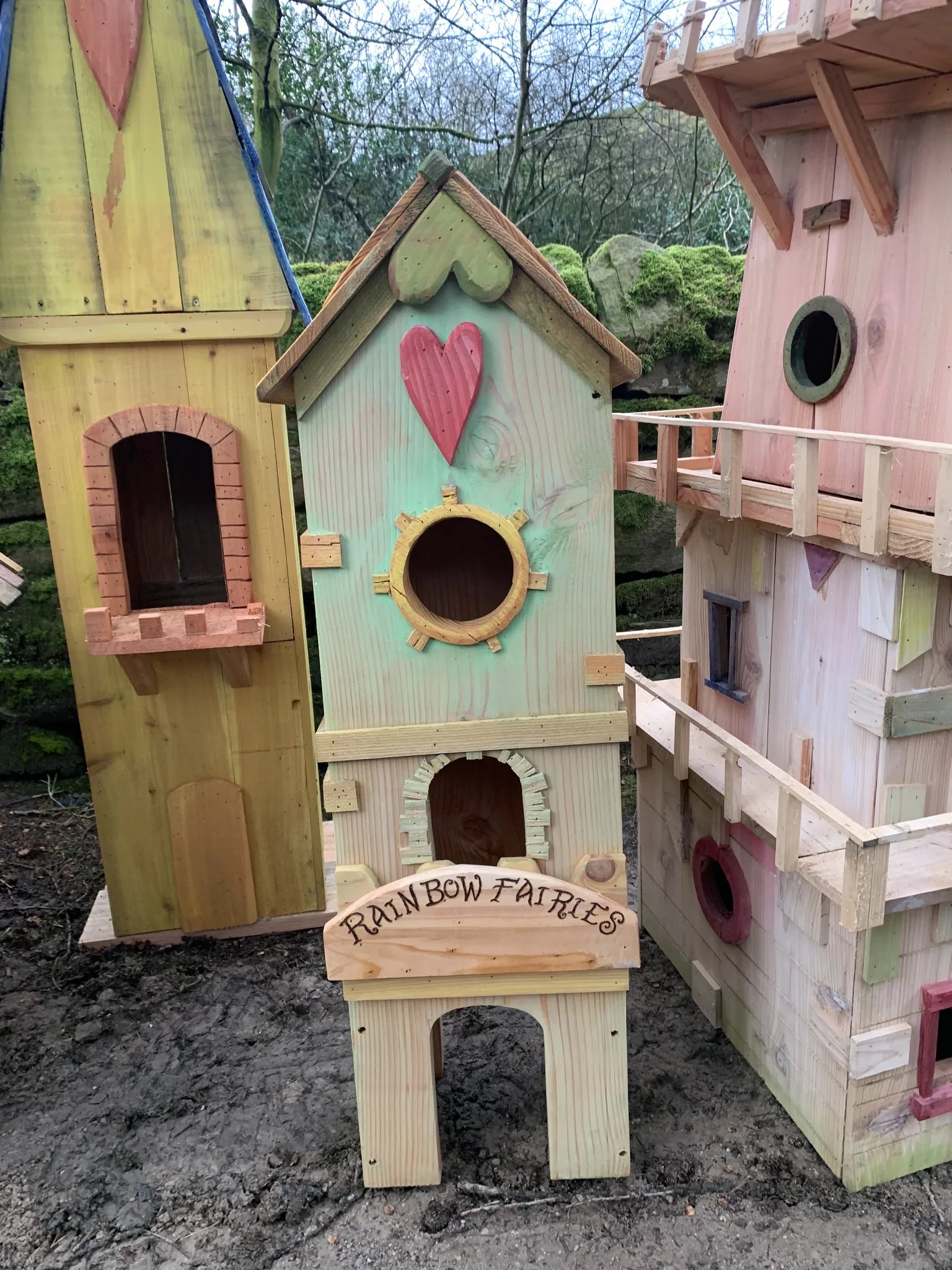 Side view of mini fairy house showing hand-painted decorations and compact solid wood design