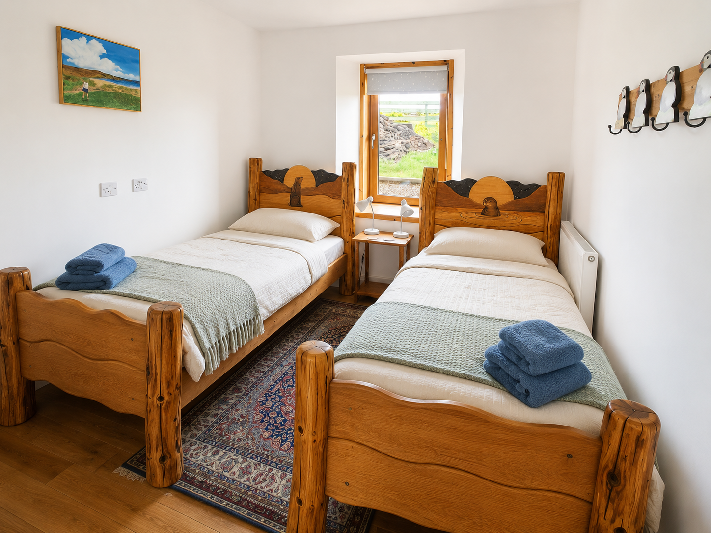 Matching hare and seal single beds with carved moonlit headboards in a cottage bedroom