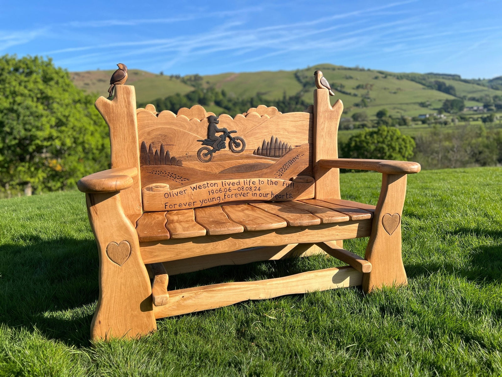 Side view of hand-carved oak memorial bench with motorbike rider silhouette — personalised tribute, Wales