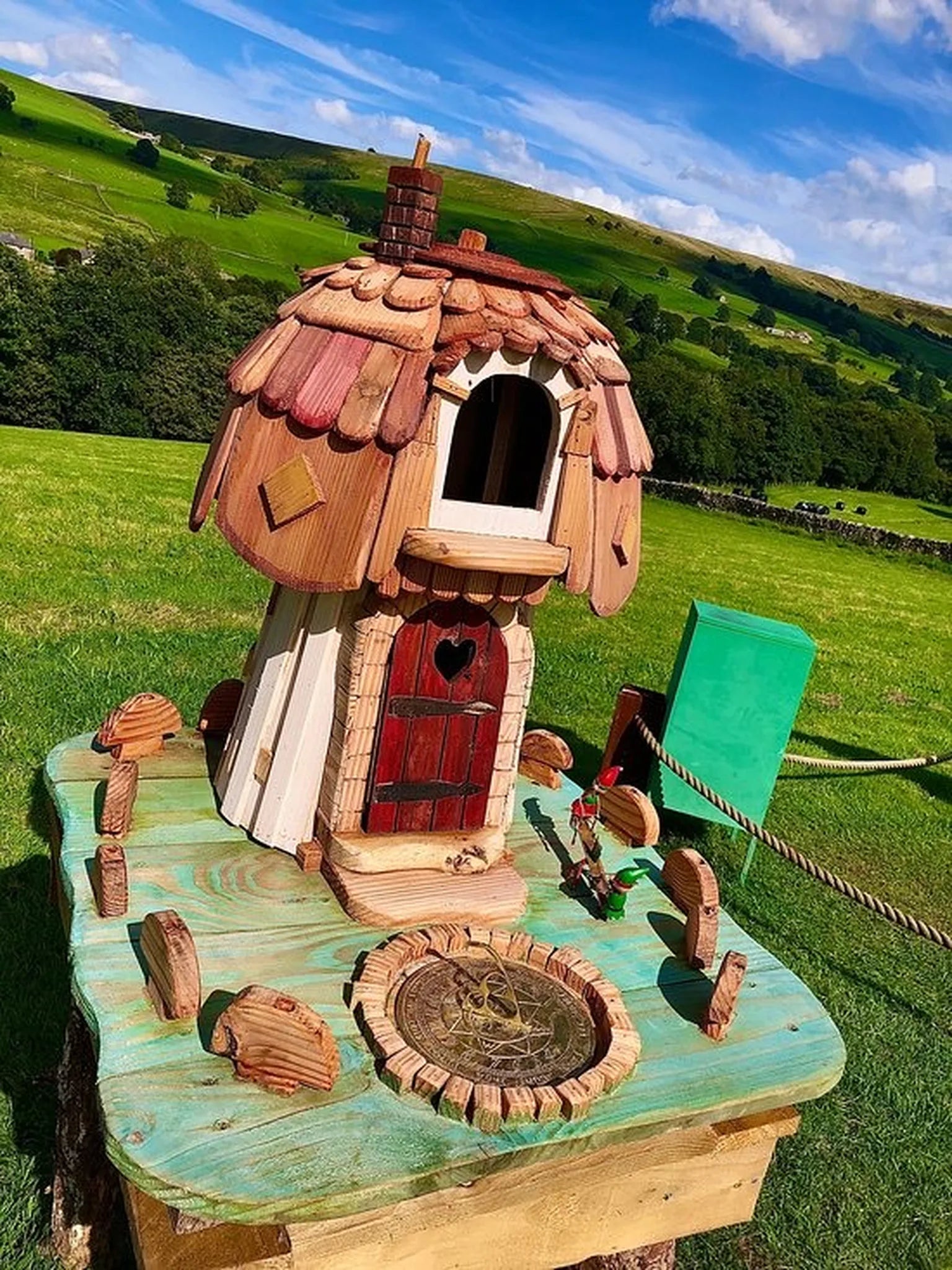 Side angle of mushroom fairy house showing hexagonal solid wood construction and toadstool cap