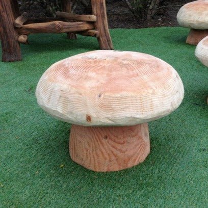 Natural wood handmade mushroom stool on grass — bespoke carved seating, Wales