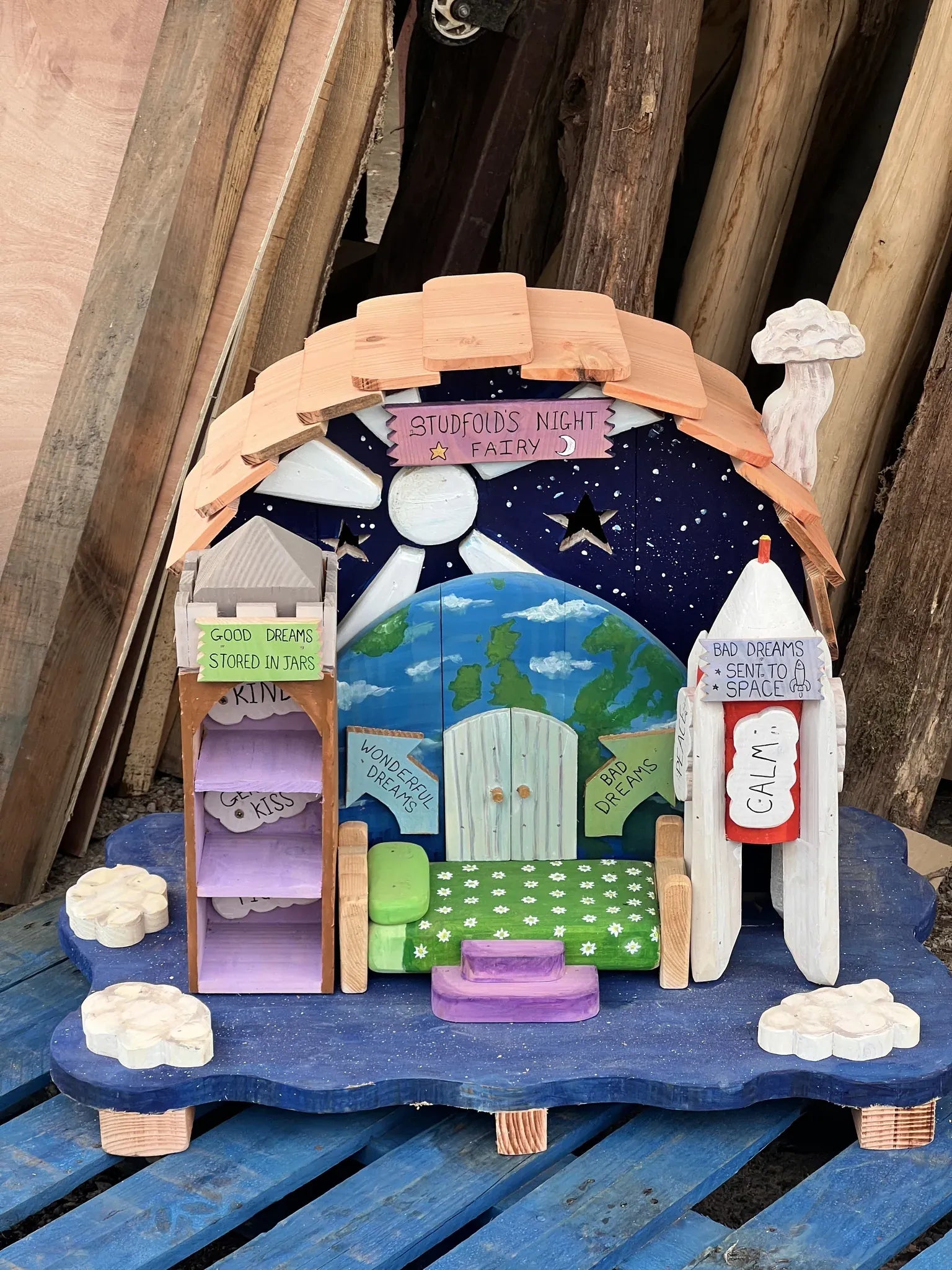 Side view of night fairy dream house showing cosmic hand-painted details and dark timber construction