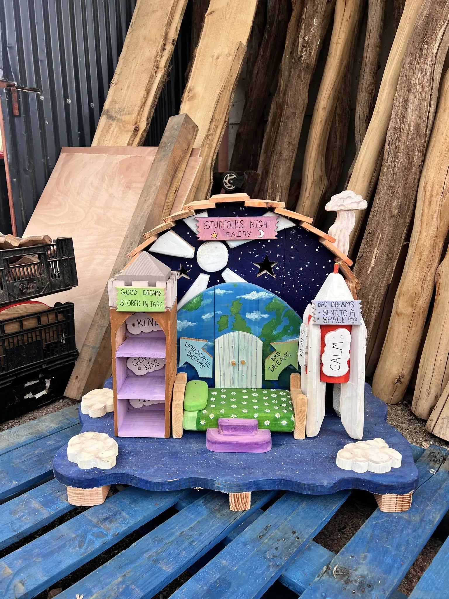 Close-up of night fairy house star and moon decorations hand-painted on dark solid wood walls