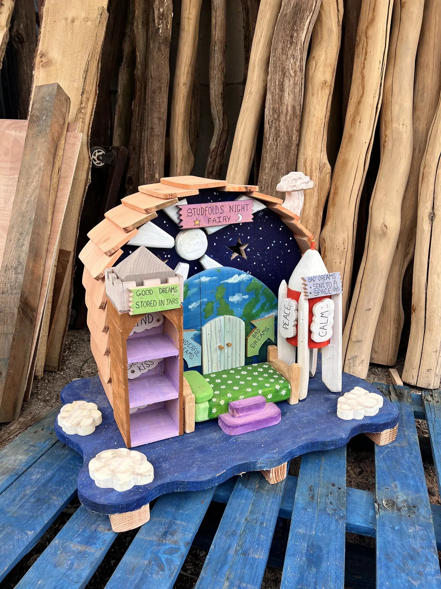 Rear view of night fairy dream house showing dark reclaimed timber and hand-painted celestial details