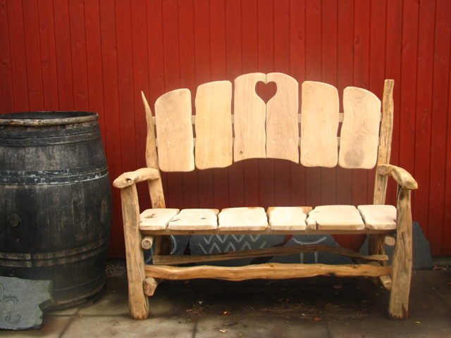 Side view of rustic handmade oak heart fan bench — bespoke garden seating, Wales