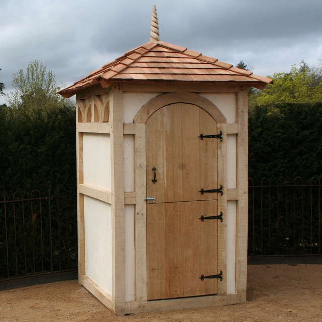 Timber Frame Composting Toilet with solid oak frame, medieval arches, stable door, and decorative roof finial, blending traditional design with eco-conscious functionality