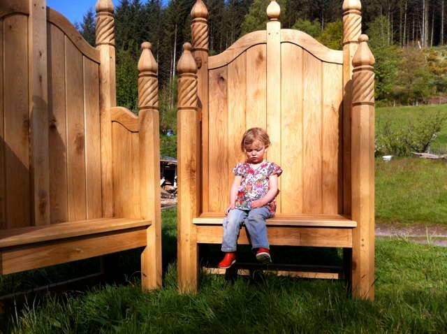 Child seated on ornate hand-carved oak storytelling chair — bespoke, Wales