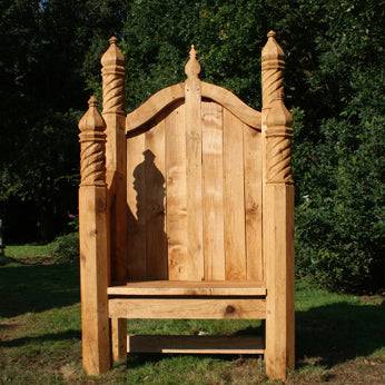 Single ornate hand-carved oak storytelling chair outdoors — bespoke, handmade in Wales