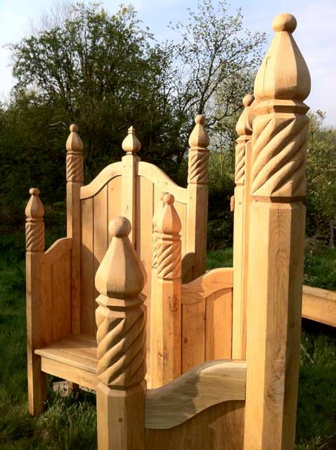 Detailed view of hand-carved oak storytelling chair posts — bespoke ornate carving, Wales