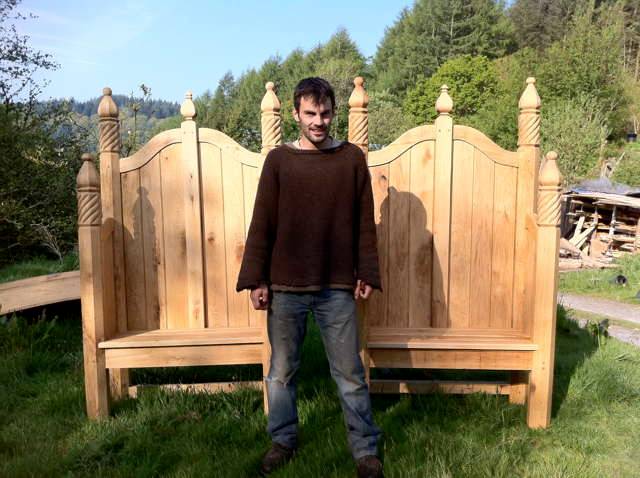 Person standing in front of ornate hand-carved oak storytelling chairs — bespoke, Wales