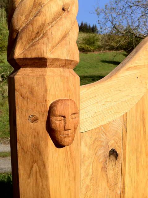 Close-up of hand-carved face detail on oak storytelling chair — bespoke, Wales