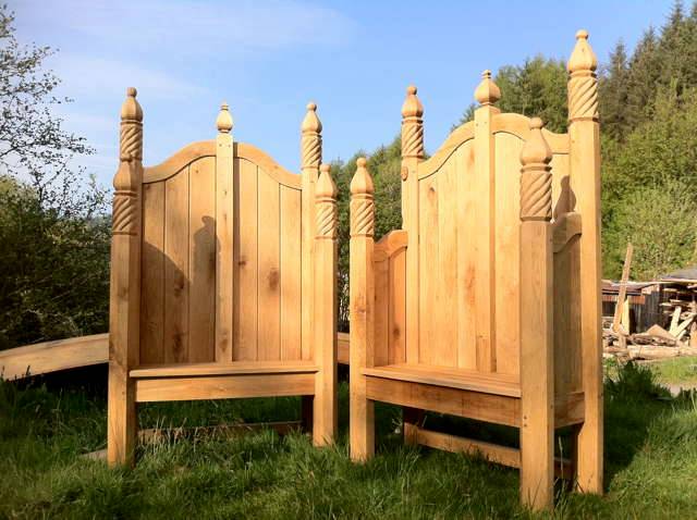 Ornate hand-carved oak storytelling chairs in sunny garden — bespoke, Wales