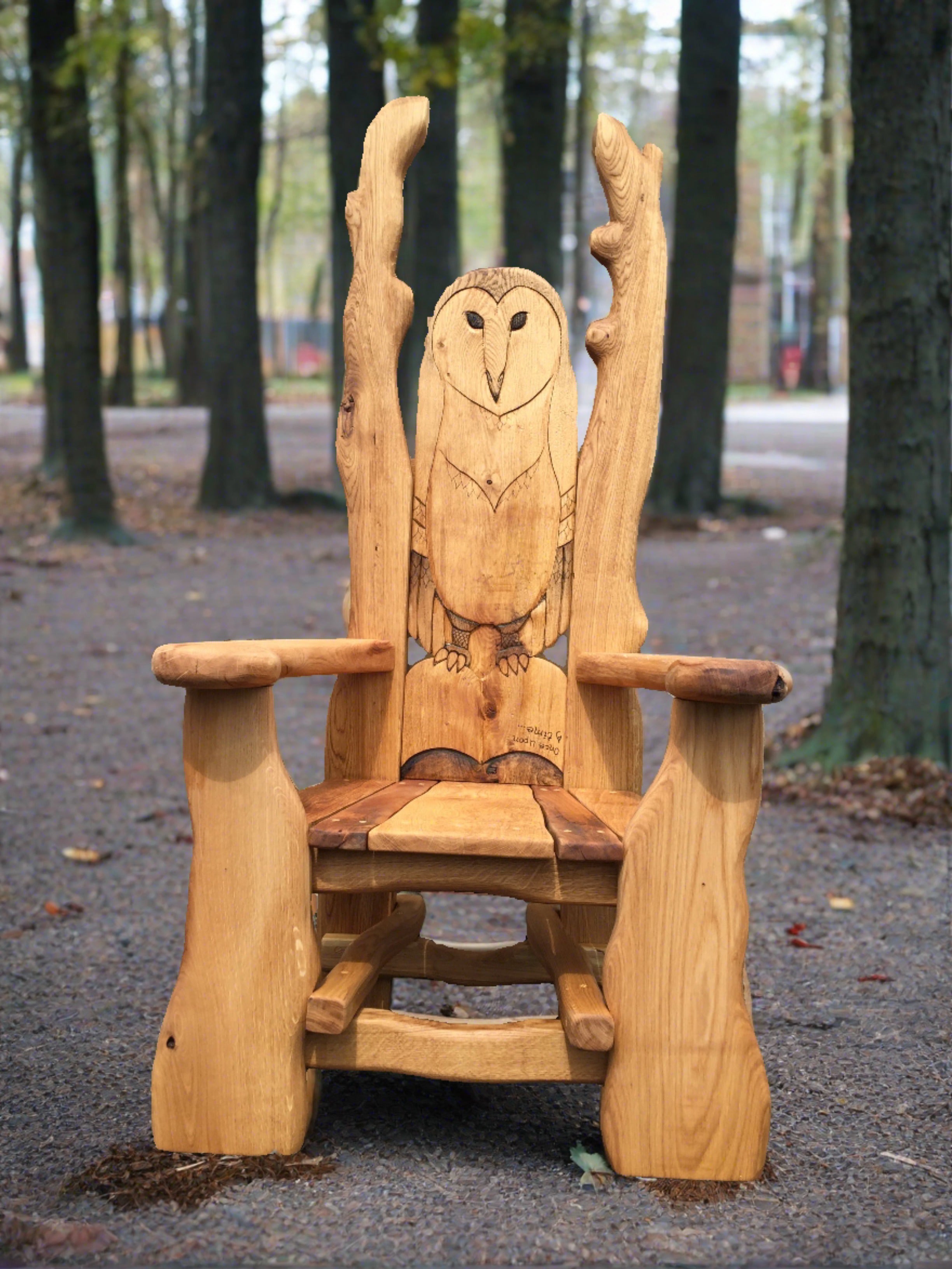 Chaise en bois avec hibou sculpté dans un cadre forestier.