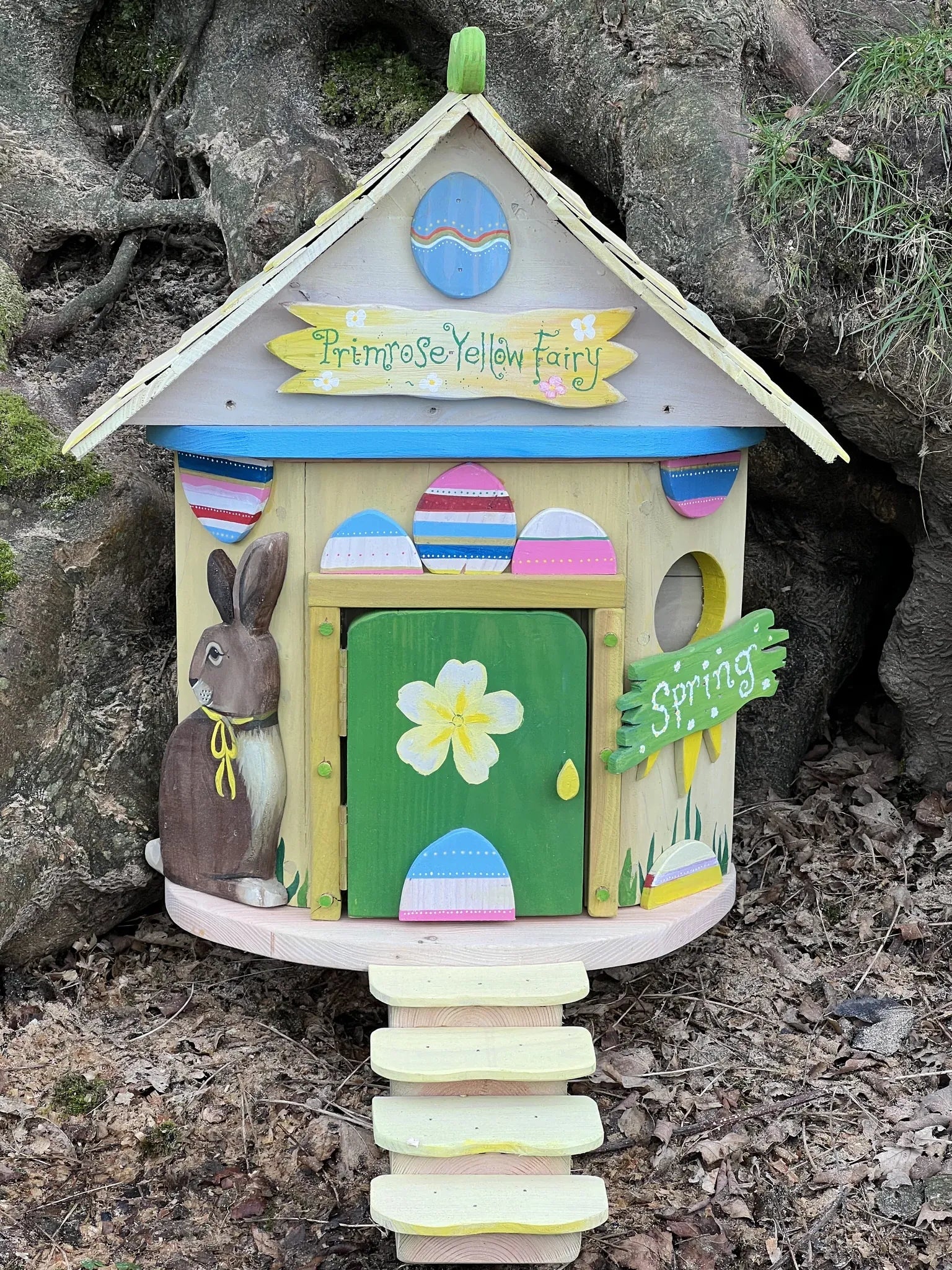 Side view of primrose yellow fairy cottage showing pale yellow paintwork and solid wood frame