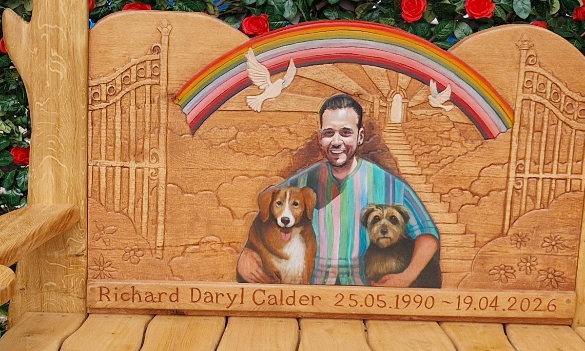 Close-up of the carved oak backrest: rainbow over open gates, doves, a path of light and a hand-painted portrait with two dogs