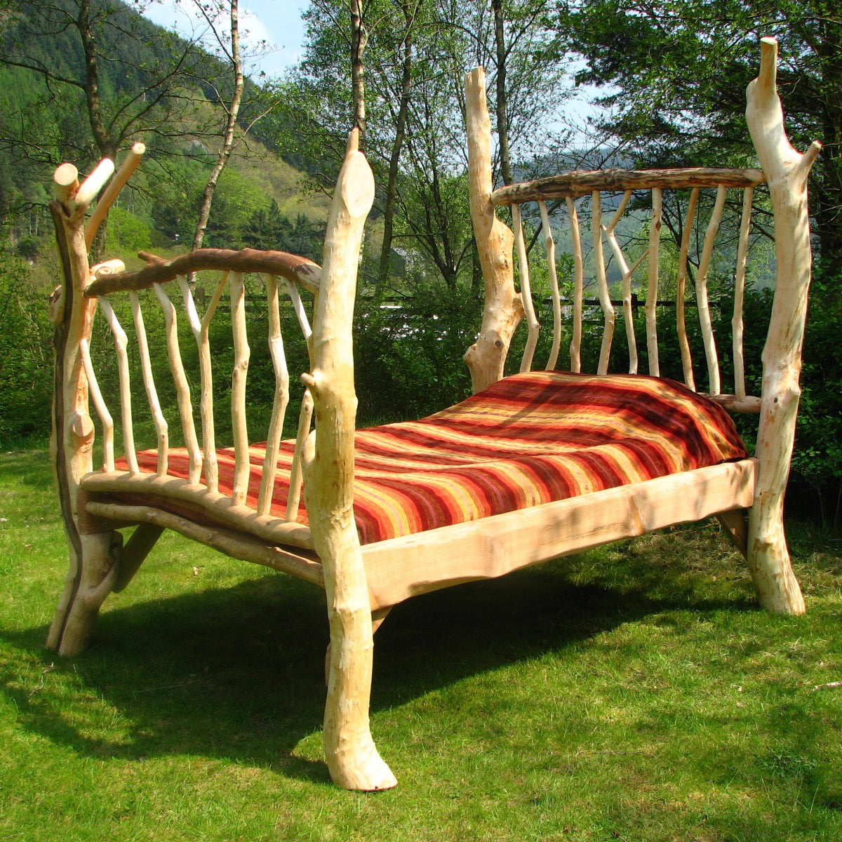 Handmade rustic driftwood four-poster bed with sustainable Welsh materials, featuring a natural and eco-friendly design for unique homes and B&Bs.