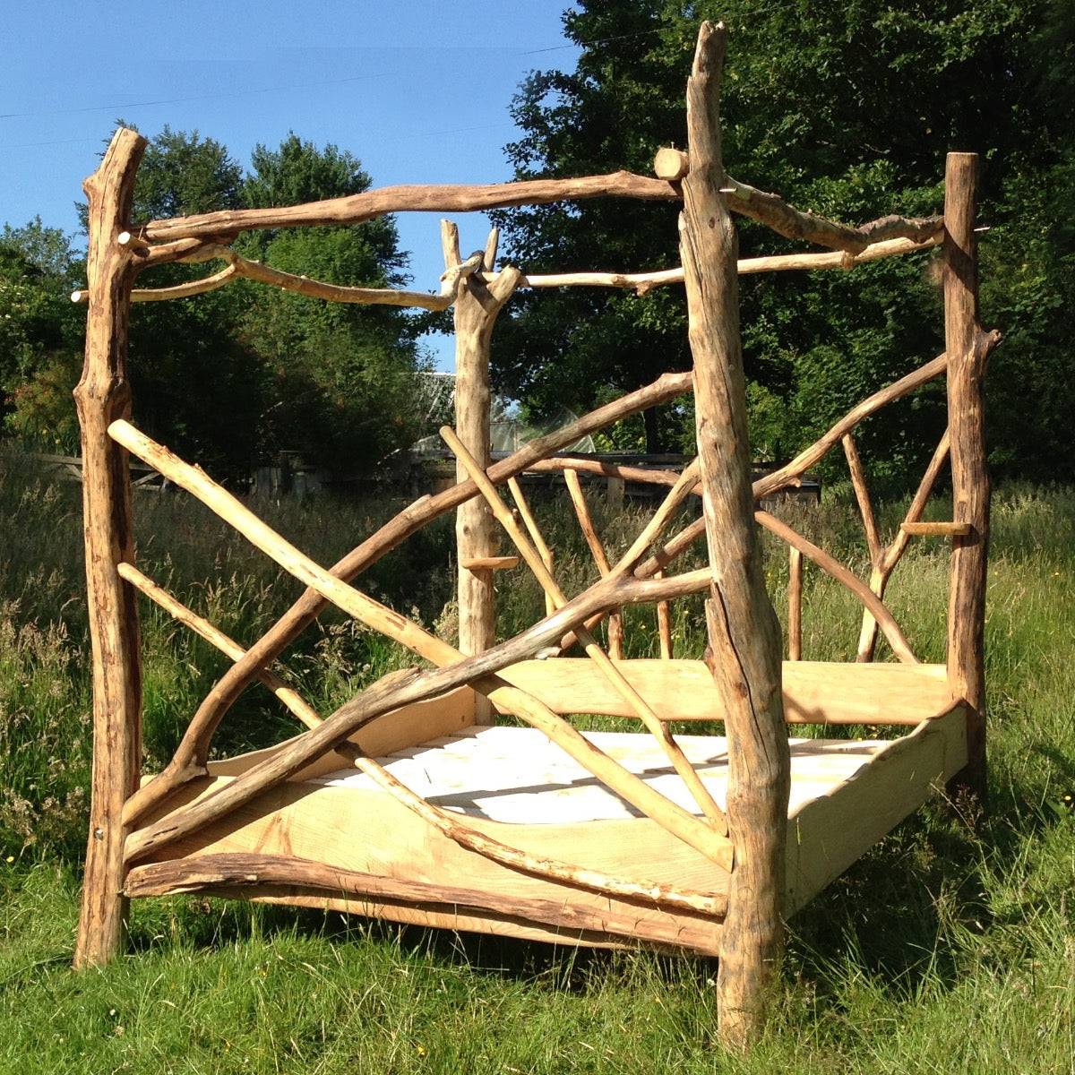 Rustic driftwood four poster canopy bed frame, handmade with sustainable Welsh timber, showcasing natural design and timeless craftsmanship for elegant bedrooms.