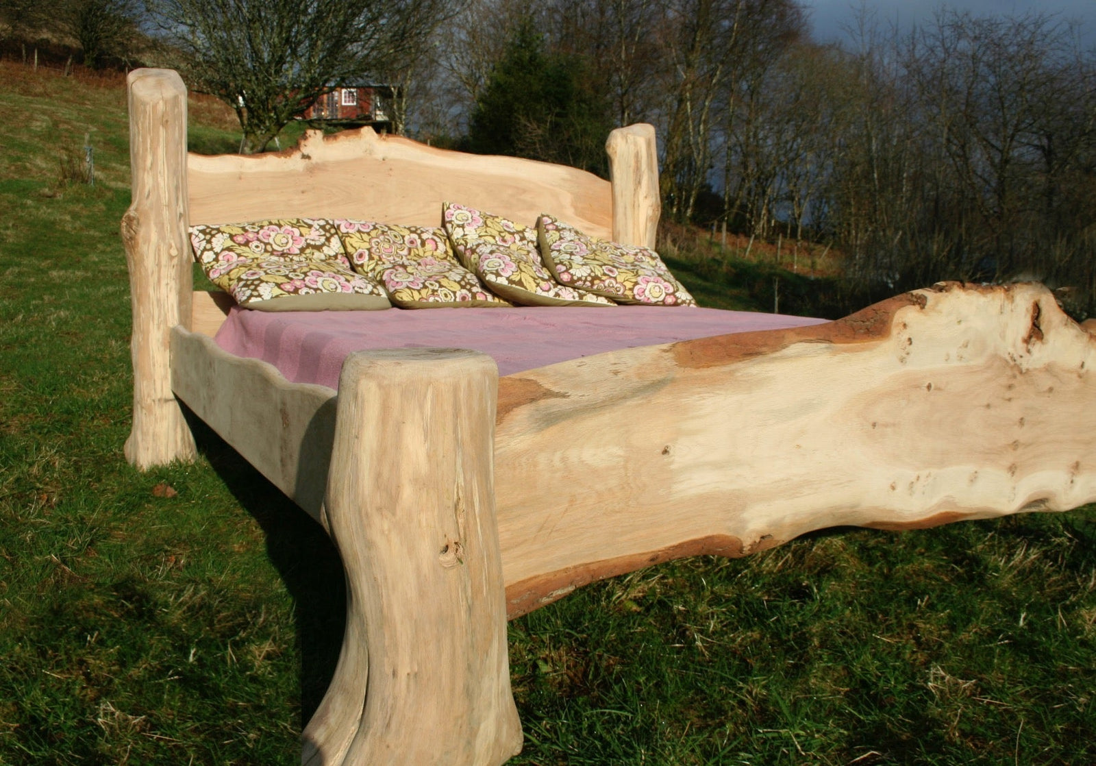 Handmade rustic oak driftwood bed in natural setting — bespoke bedroom furniture, Wales