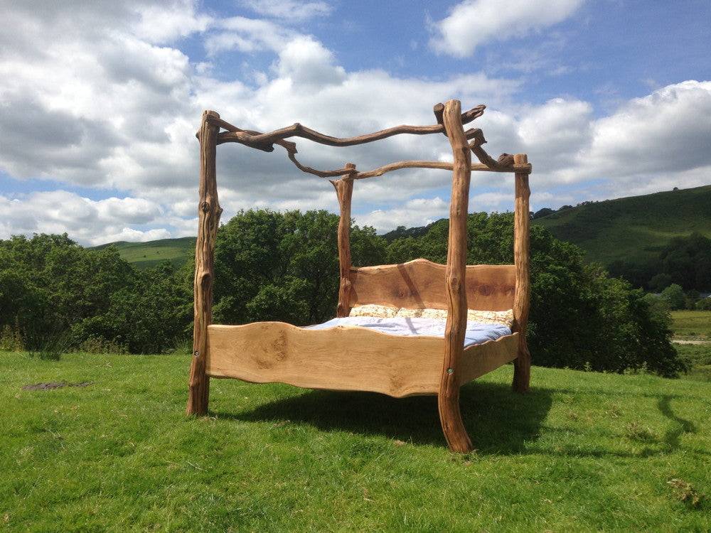 Handmade oak four poster bed in outdoor garden setting — rustic bespoke bedroom furniture, Wales