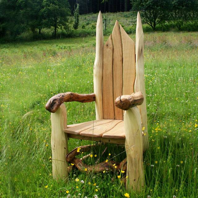 Rustic carved oak reading throne in school outdoor area — handmade in Wales