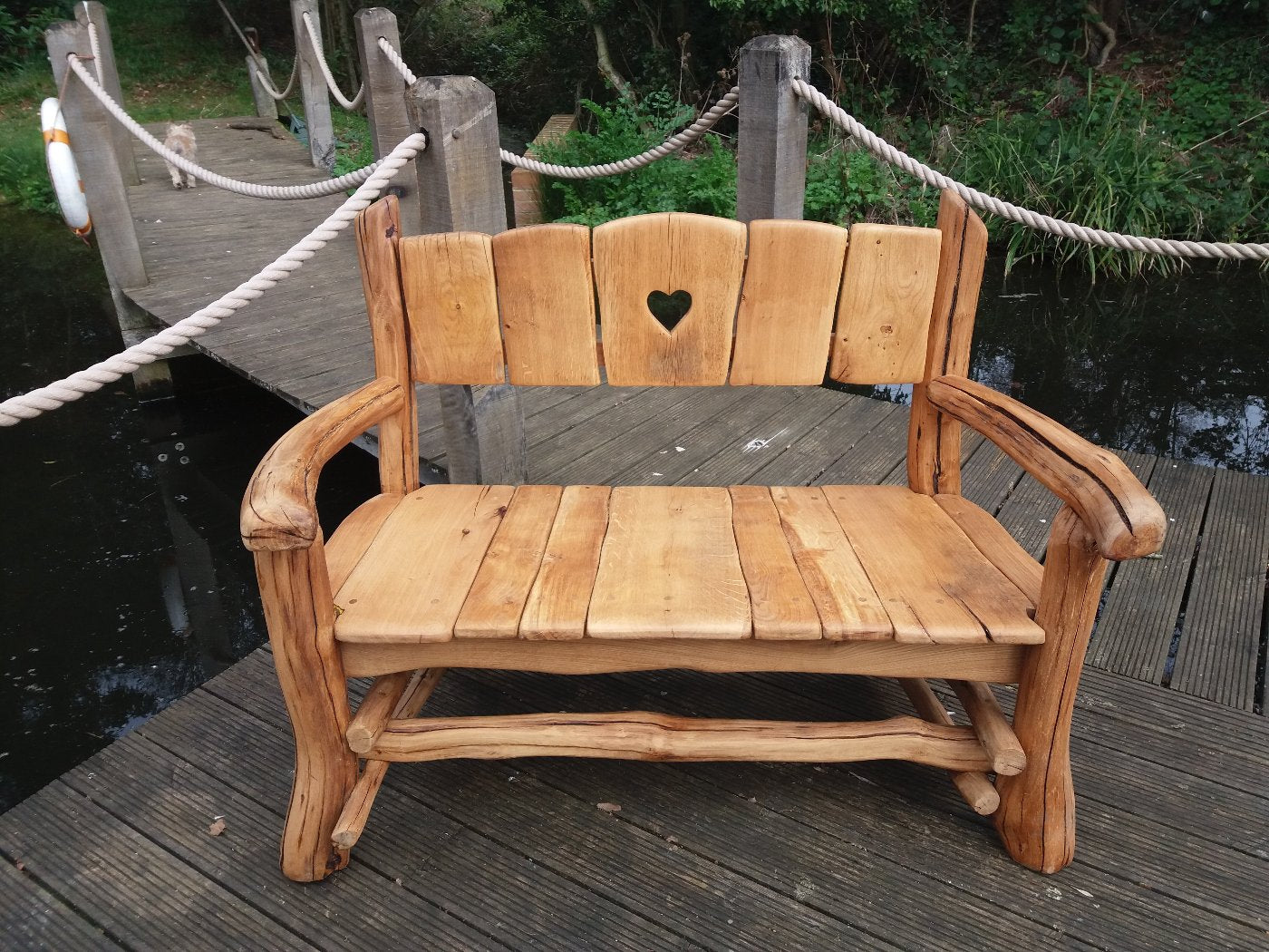 rustic wooden bench next to pond in a park in London