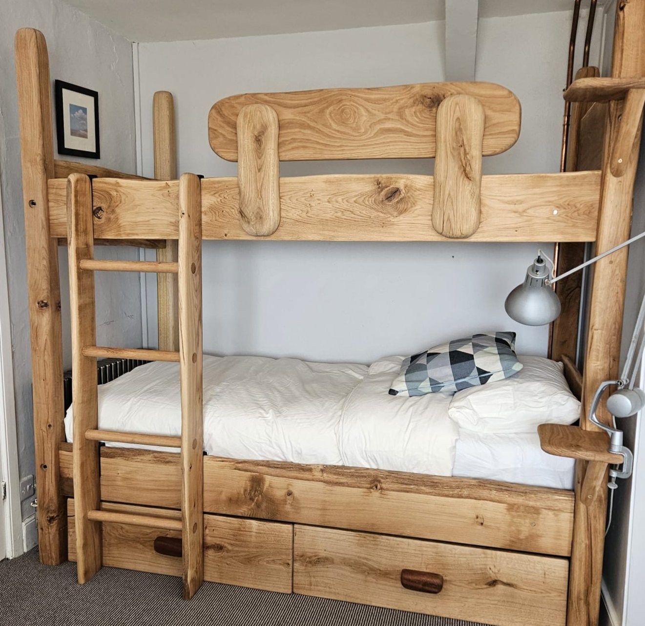 Rustic wooden bunk bed with natural wood finish, featuring sturdy ladder, storage drawers, and a minimalist design, ideal for a cozy bedroom setting