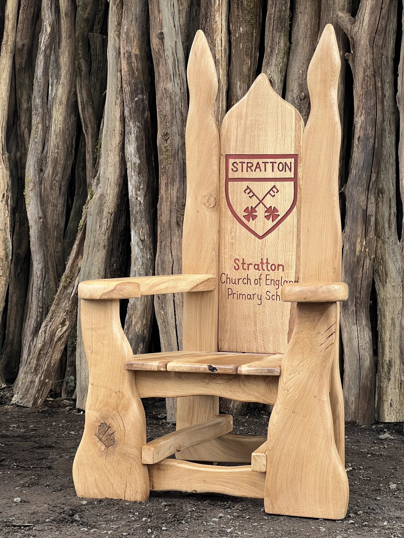 Hand-carved oak storytelling chair carved with the Stratton Church of England Primary School crest and name