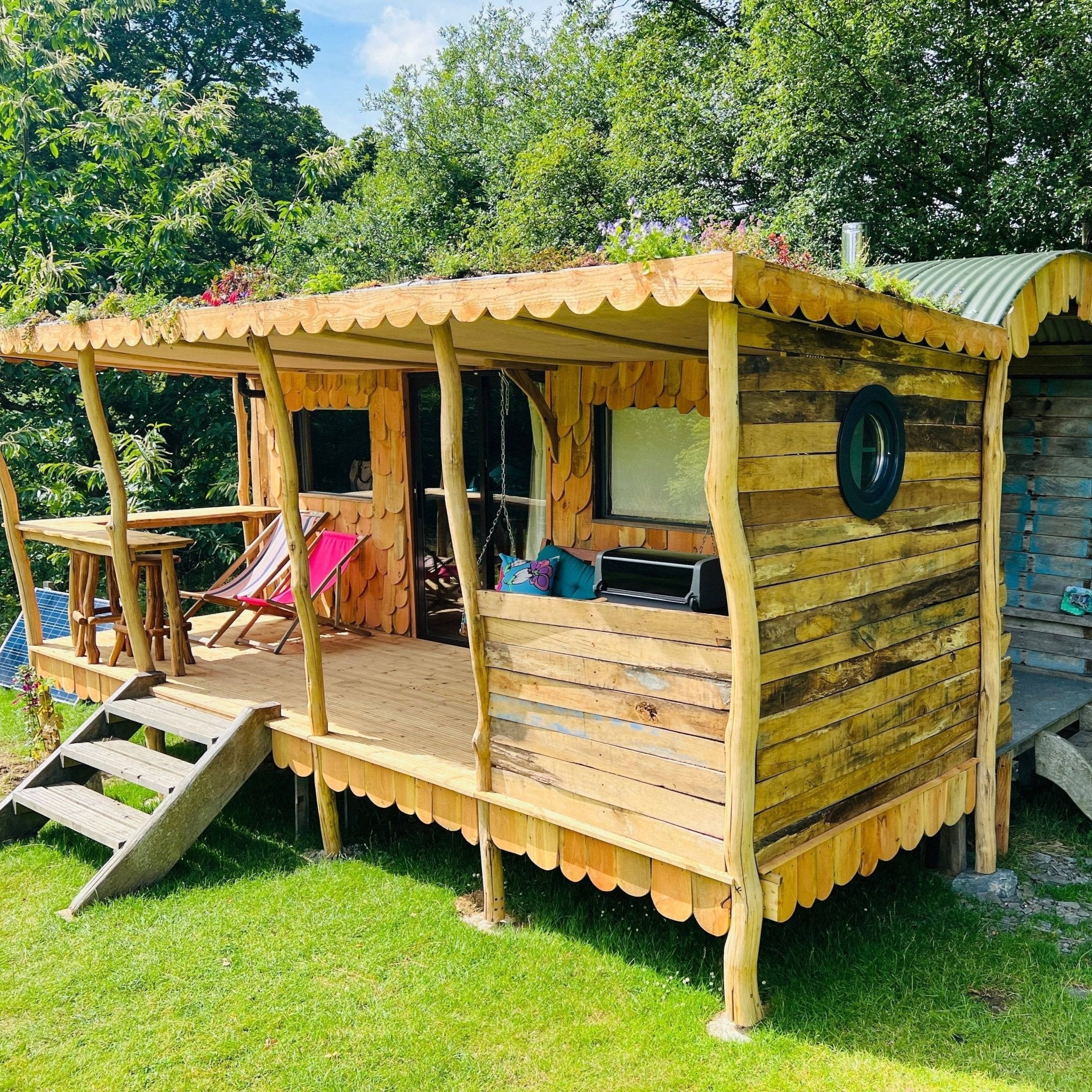 Wooden shepherd's hut exterior with porch and greenery