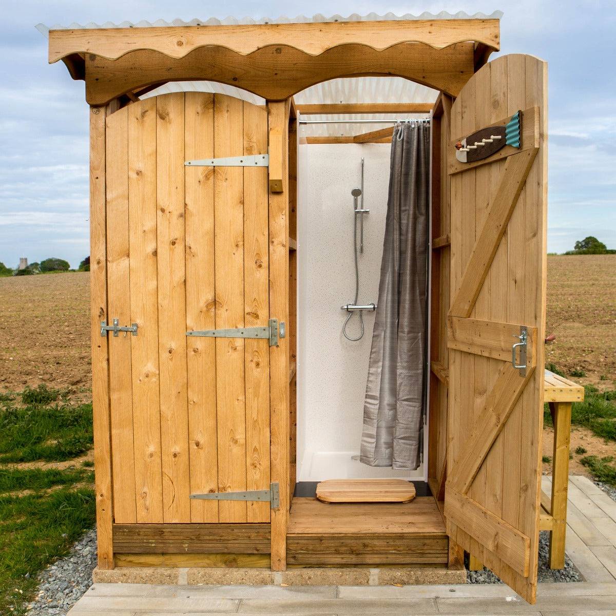 Outdoor Shower and Composting Toilet Unit with natural wood construction, showcasing a stylish shower area and compact design for eco-friendly sanitation.

