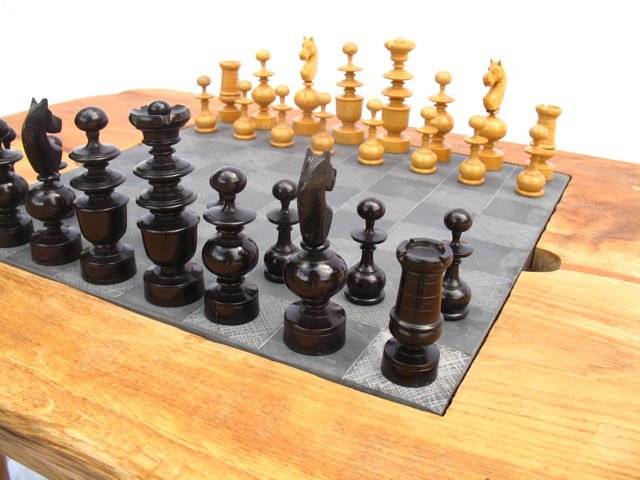 Chess pieces on handmade oak chess table — bespoke slate and oak game table, Wales
