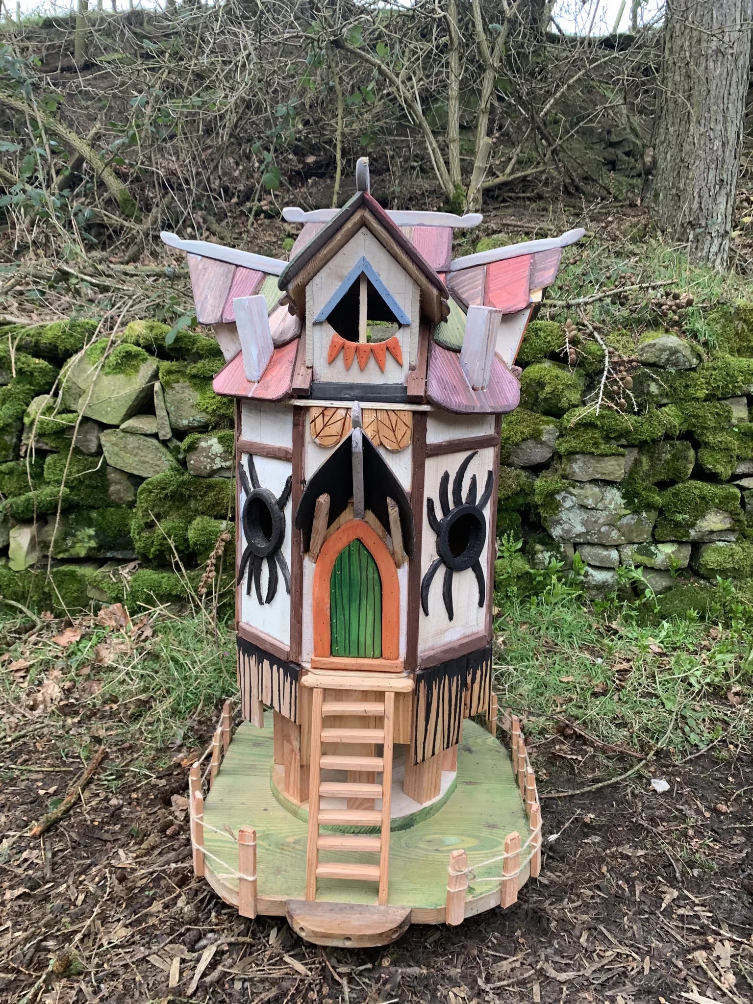 Side view of gothic spider fairy house showing dark painted timber and hand-painted cobweb details