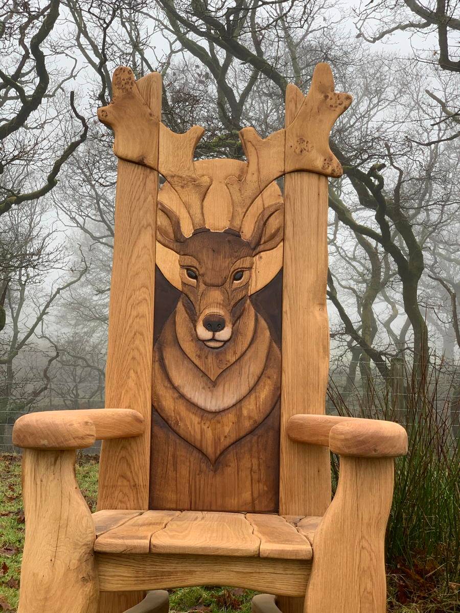 Carved oak stag storytelling chair in misty woodland — handmade reading throne, Wales