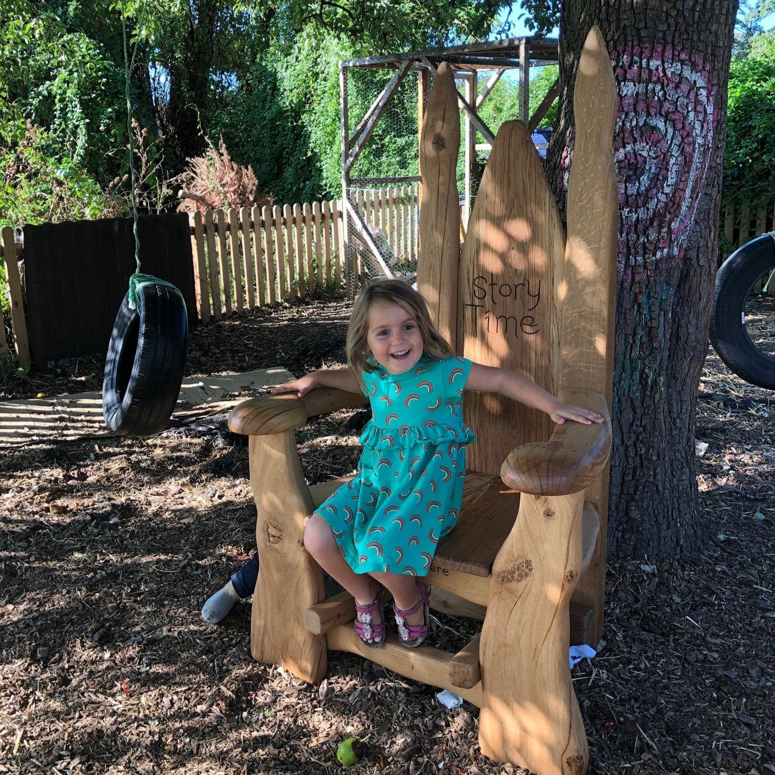 Handcrafted Storyteller’s Chair with a child seated, placed outdoors under a tree, symbolizing imagination and storytelling magic