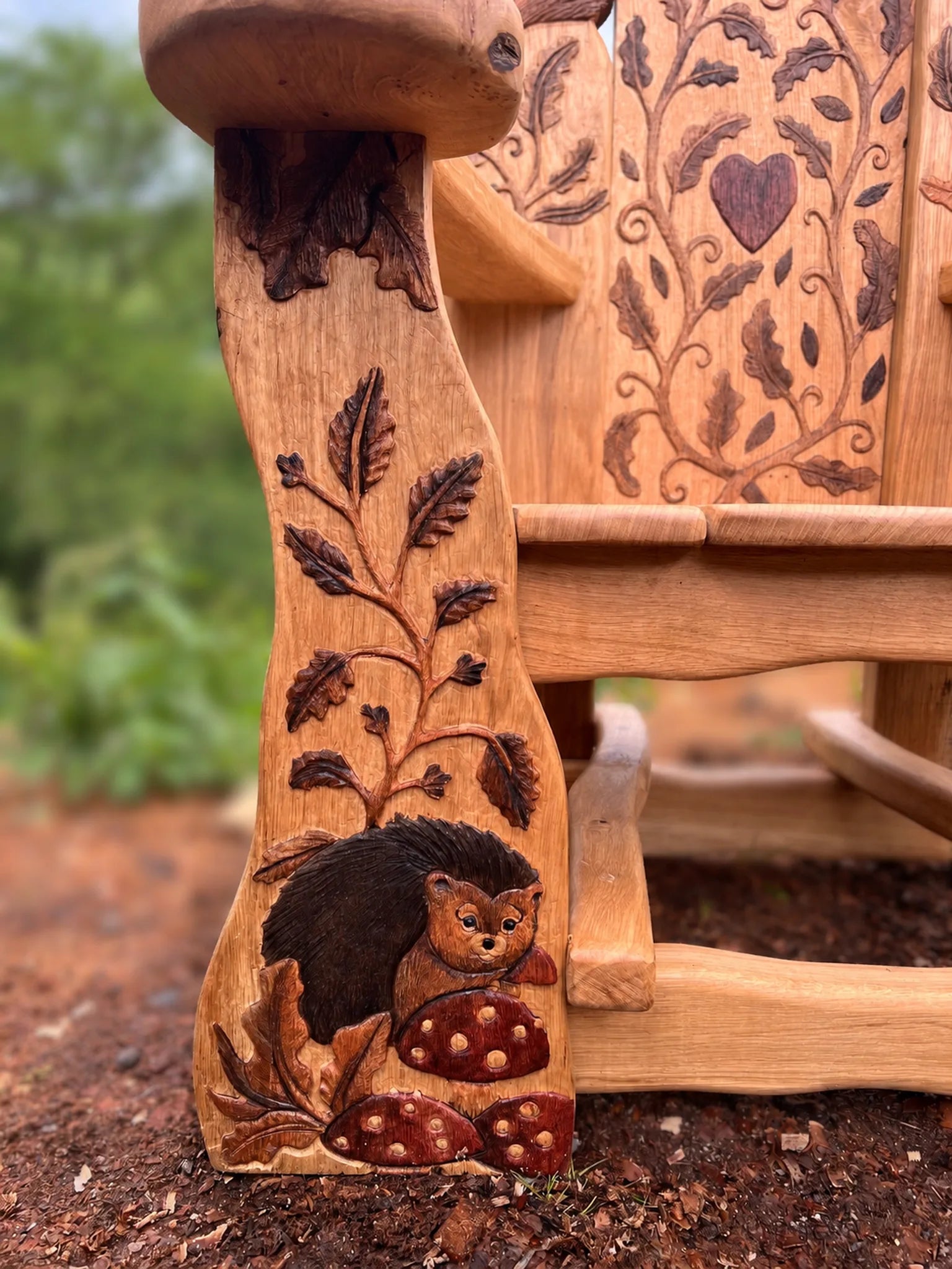 Hand-carved hedgehog among oak leaves and toadstools on the arm of a woodland storytelling throne chair
