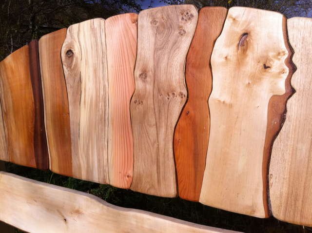 Stripy driftwood bed in bedroom — handmade sustainable colourful wood furniture, Wales